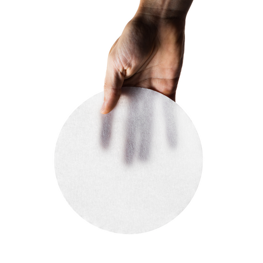 Hand holding a paper filter against a white background
