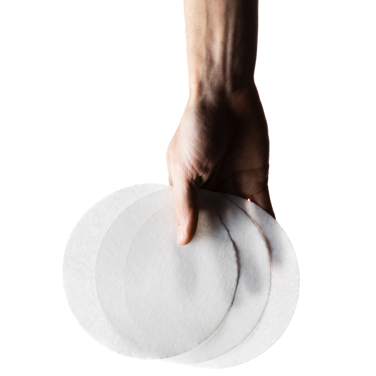 Hand holding flat paper filters against a white background